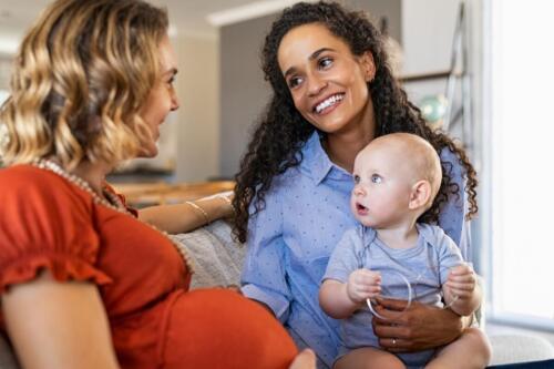 Happy,Multiethnic,Friends,With,Child,Relaxing,At,Home.,Mixed,Race