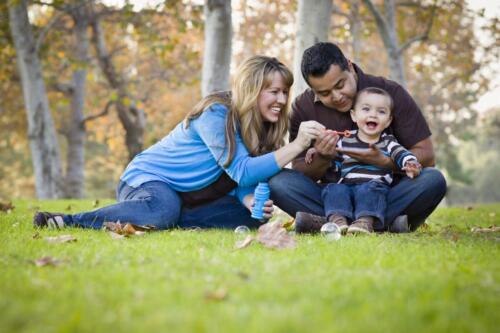 Happy,Young,Mixed,Race,Ethnic,Family,Playing,Together,With,Bubbles