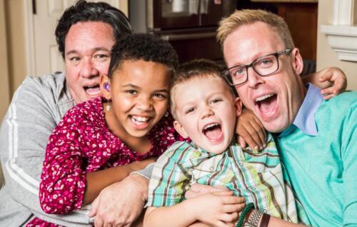 Gay,Parents,Pose,With,Their,Children,In,The,Living,Room